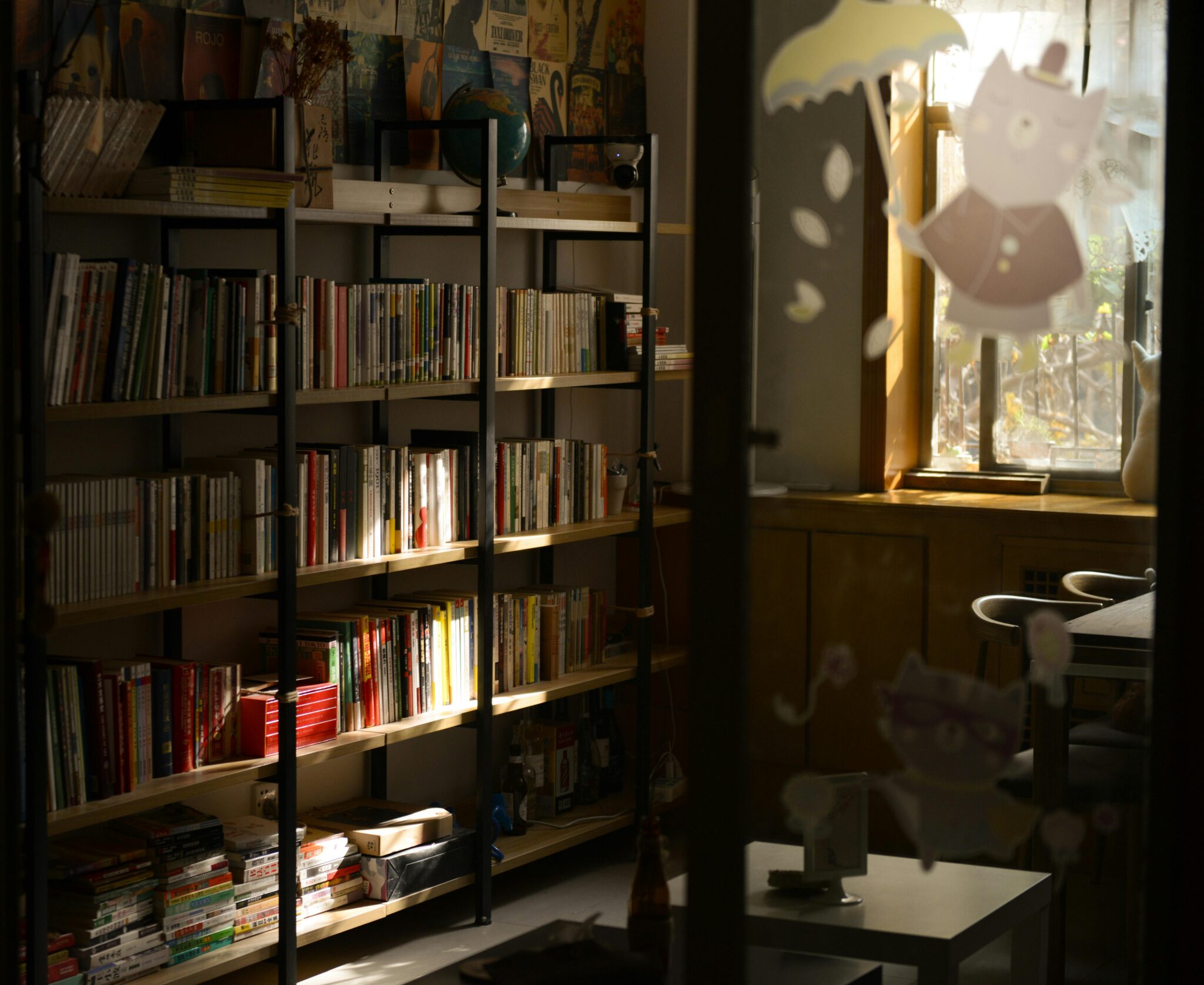 Warm sunlight illuminates a cozy library corner with wooden bookshelves filled with books.